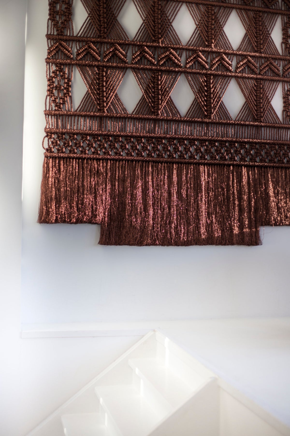 Close-up of the shimmering copper-brown two-tier fringe and knotted diamonds